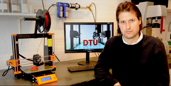 Jon Spangenberg med 3D printer og kopi af printeren på skærmen. Fotograf: Flemming Jørgensen